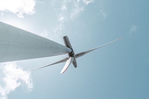 Free Low angle view of a modern wind turbine against a clear blue sky, symbolizing renewable energy. Stock Photo