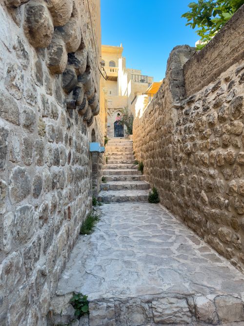Free Explore a scenic stone pathway in the historic city of Mardin, Türkiye, captured in vibrant daylight. Stock Photo