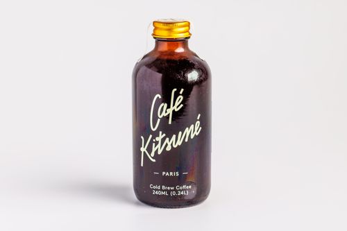Free A minimalistic shot of Café Kitsuné cold brew coffee bottle with white backdrop. Stock Photo