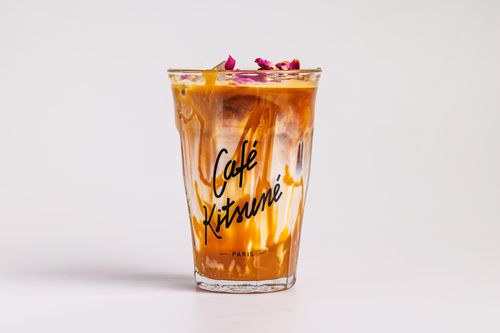 De franc Cafè gelat refrescant en un got de marca de Café Kitsuné amb guarnició floral. Foto d'estoc