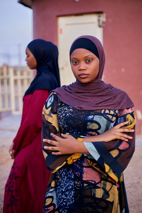 Free Two women in vibrant Nigerian traditional attire, standing confidently outdoors. Stock Photo