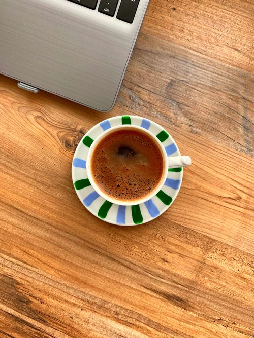 Free Overhead view of a Turkish coffee next to a laptop on a wooden table. Stock Photo
