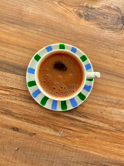 Free Cup of coffee with colorful saucer on wooden surface, top view. Stock Photo