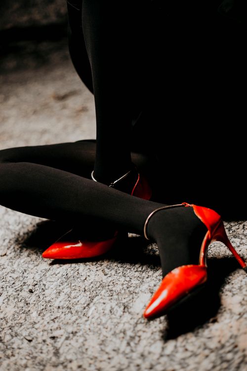 Free Stylish red high heels paired with black nylon tights for a fashionable look. Stock Photo