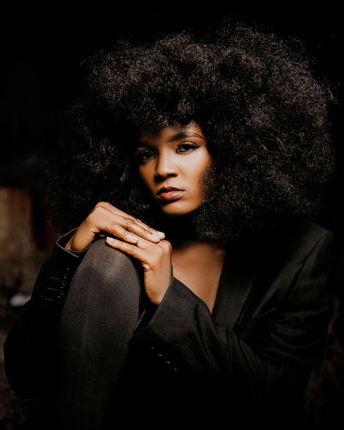 Free Striking portrait of a woman with voluminous natural curls in a black outfit, exuding elegance. Stock Photo