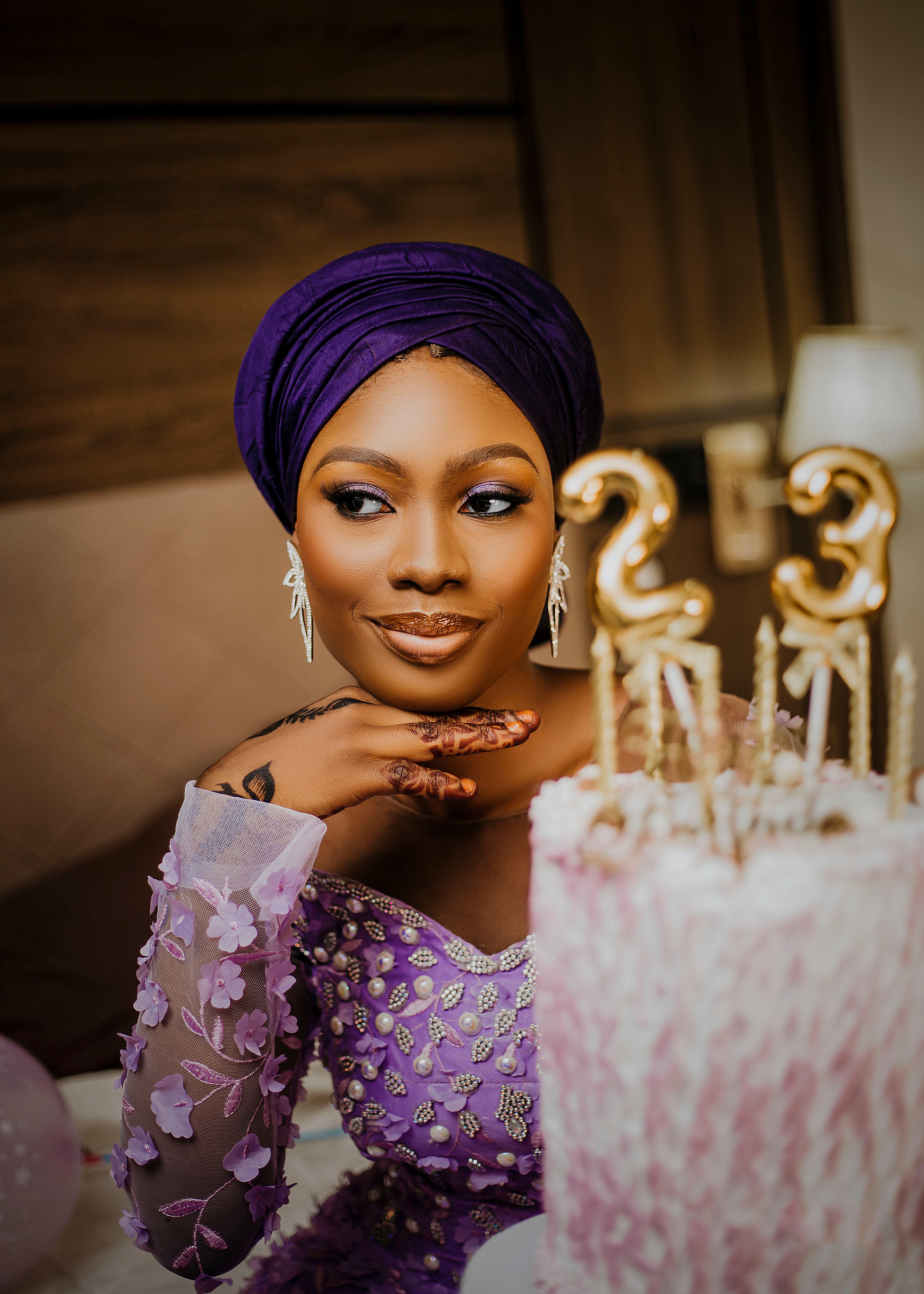 Woman celebrating her birthday with a beautifully decorated cake indoors.