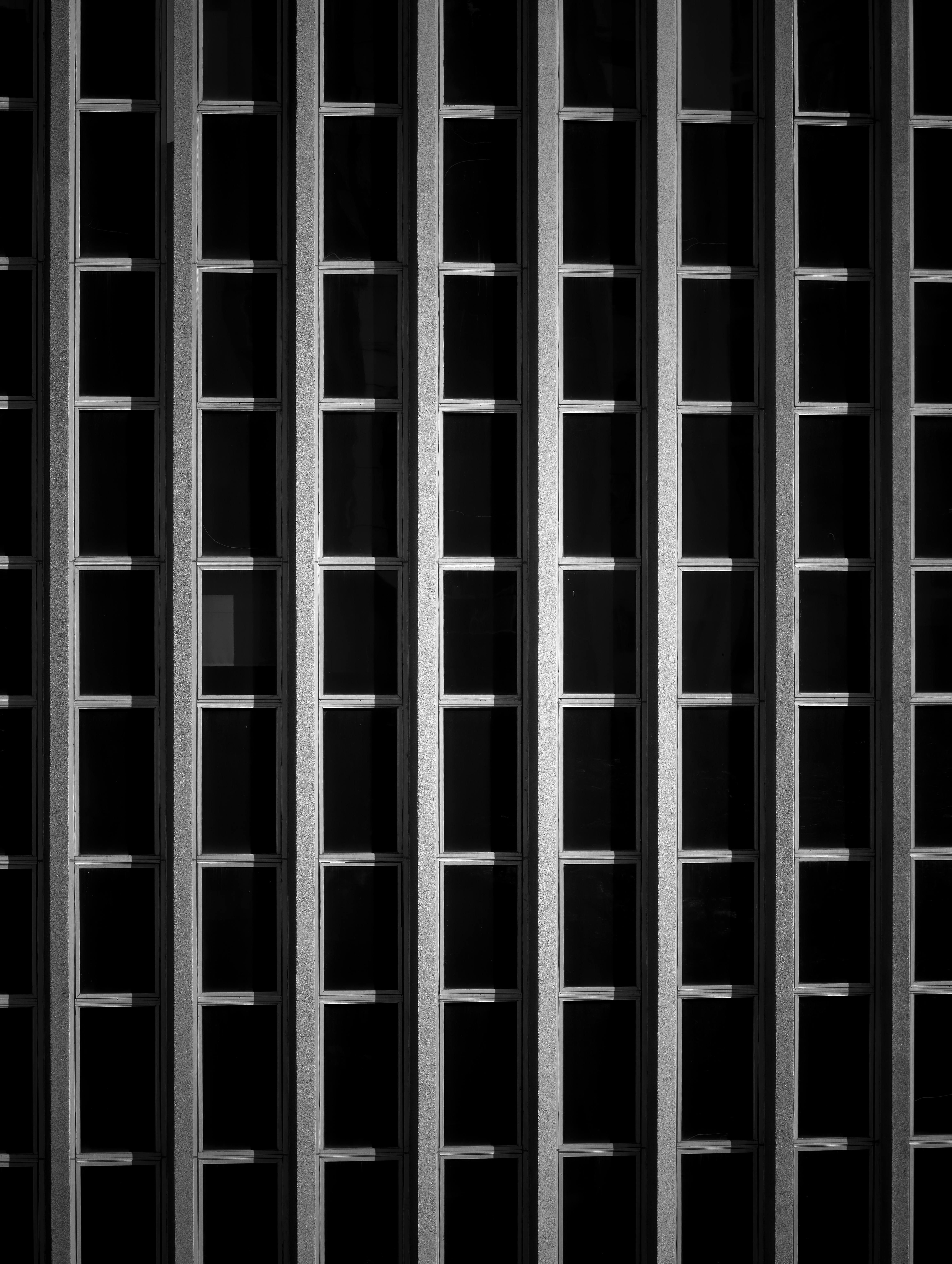 Gratis Foto astratta in bianco e nero della facciata di un edificio moderno che mette in risalto il motivo a griglia e il design geometrico. Foto a disposizione