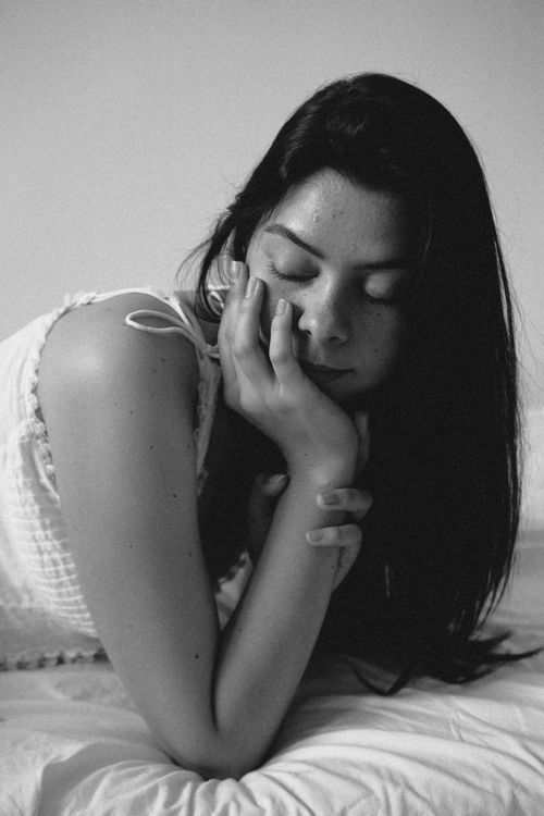 Free A serene portrait of a woman resting with closed eyes indoors, in black and white. Stock Photo