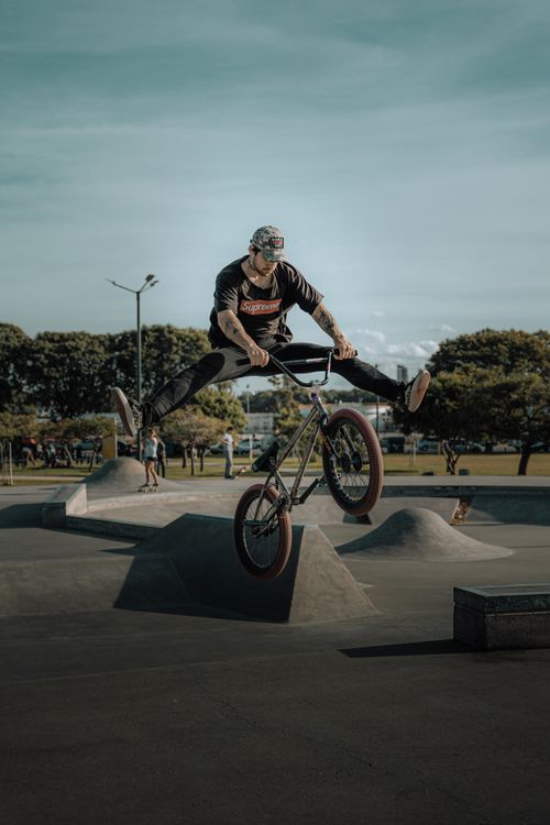 Free BMX rider performs an impressive stunt in an outdoor skatepark, capturing the thrill of extreme sports. Stock Photo