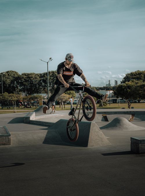 Free BMX rider performing an impressive stunt at an outdoor skatepark, showcasing skill and agility. Stock Photo