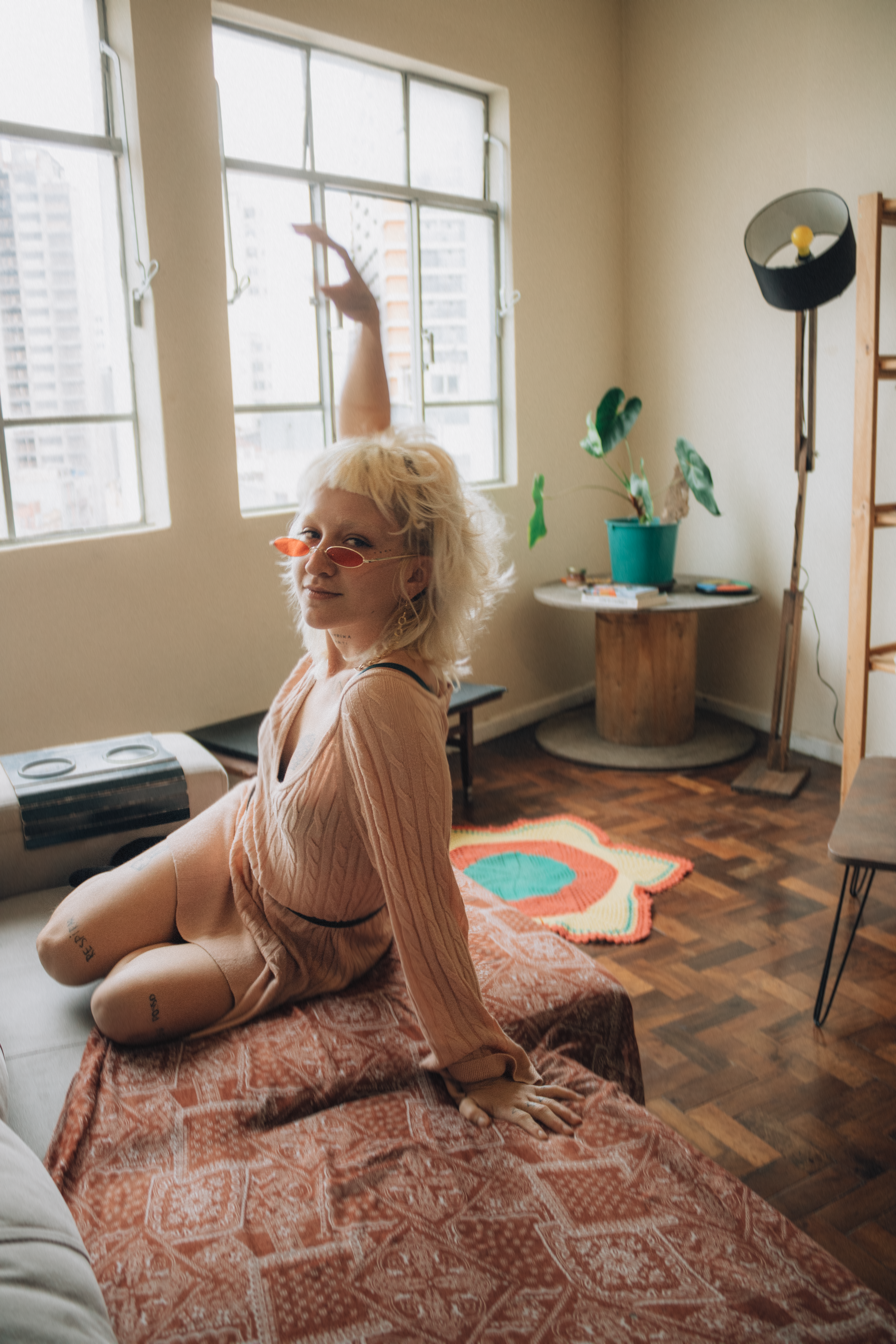 Mulher aproveitando um momento relaxante em um apartamento elegante e ensolarado.