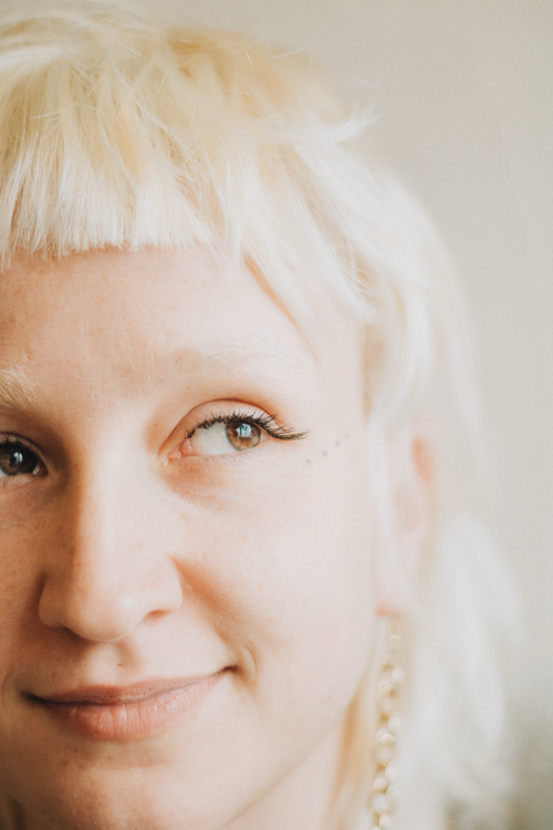Free Close-up portrait of a smiling woman with short blonde hair looking thoughtfully to the side. Stock Photo