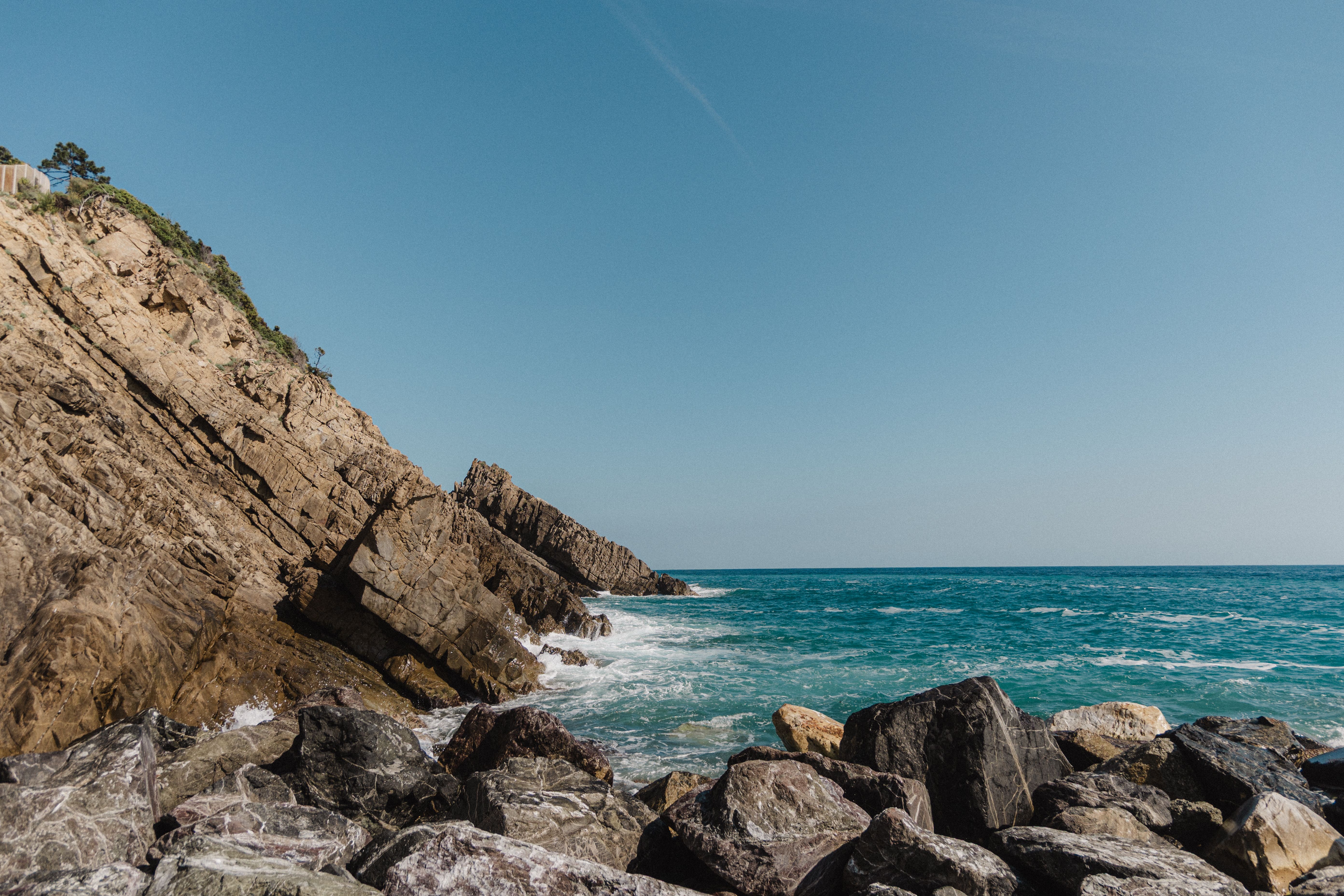 A breathtaking coastal landscape featuring rugged cliffs and vibrant blue ocean waves under a clear sky.