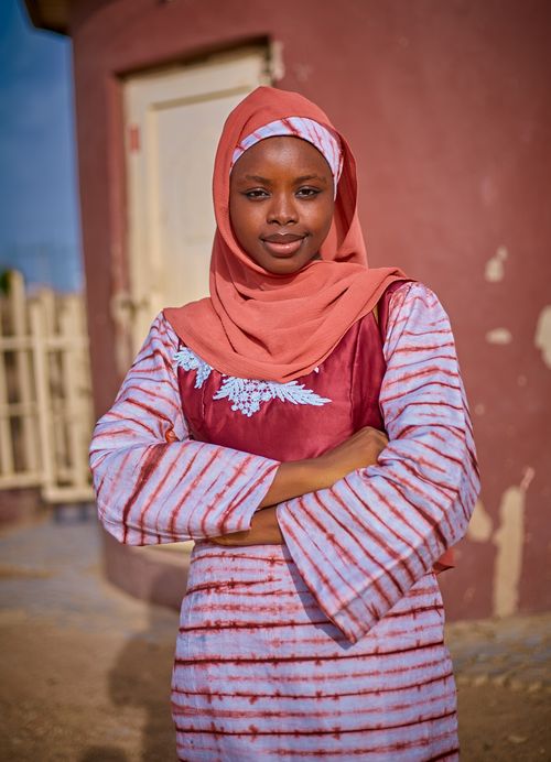 Free Portrait of a confident woman in traditional attire with a headscarf, standing outdoors. Stock Photo