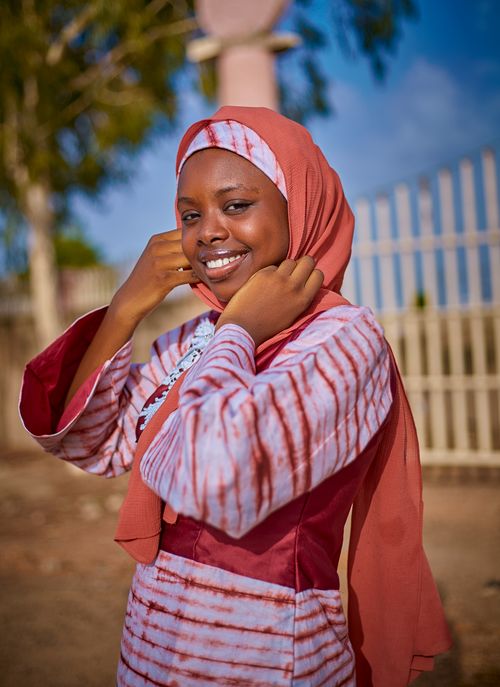 Free A joyful woman wearing a hijab enjoys a sunny day outdoors, exuding happiness. Stock Photo