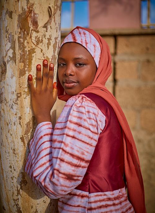 Free Young woman in traditional attire poses against a tree outdoors, showcasing cultural fashion. Stock Photo