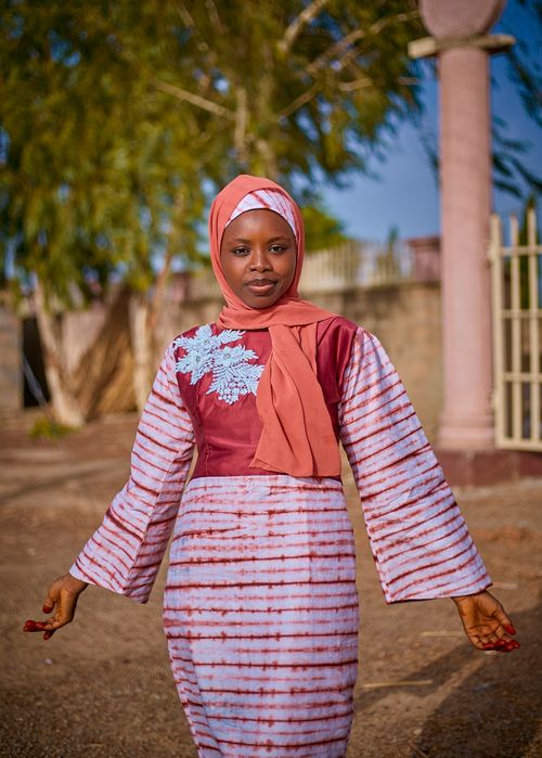 Free Confident woman in traditional African attire posing outdoors under a clear blue sky. Stock Photo