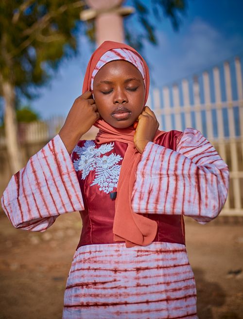 Free A young woman in a colorful traditional outfit poses outdoors. Vibrant and serene. Stock Photo