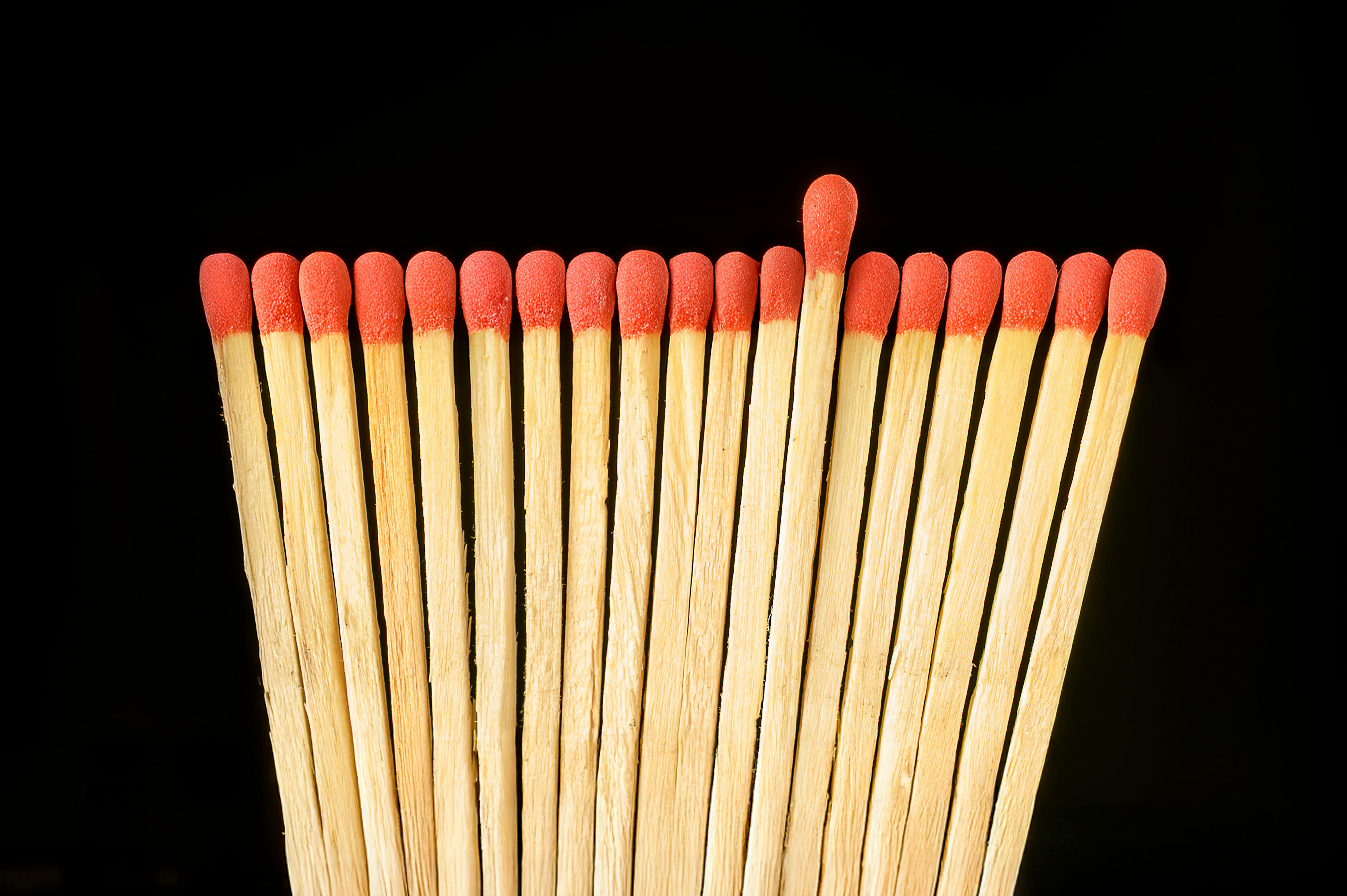 Gratis Close-up korek api berujung merah pada latar belakang hitam, menonjolkan keunikan. Foto Stok