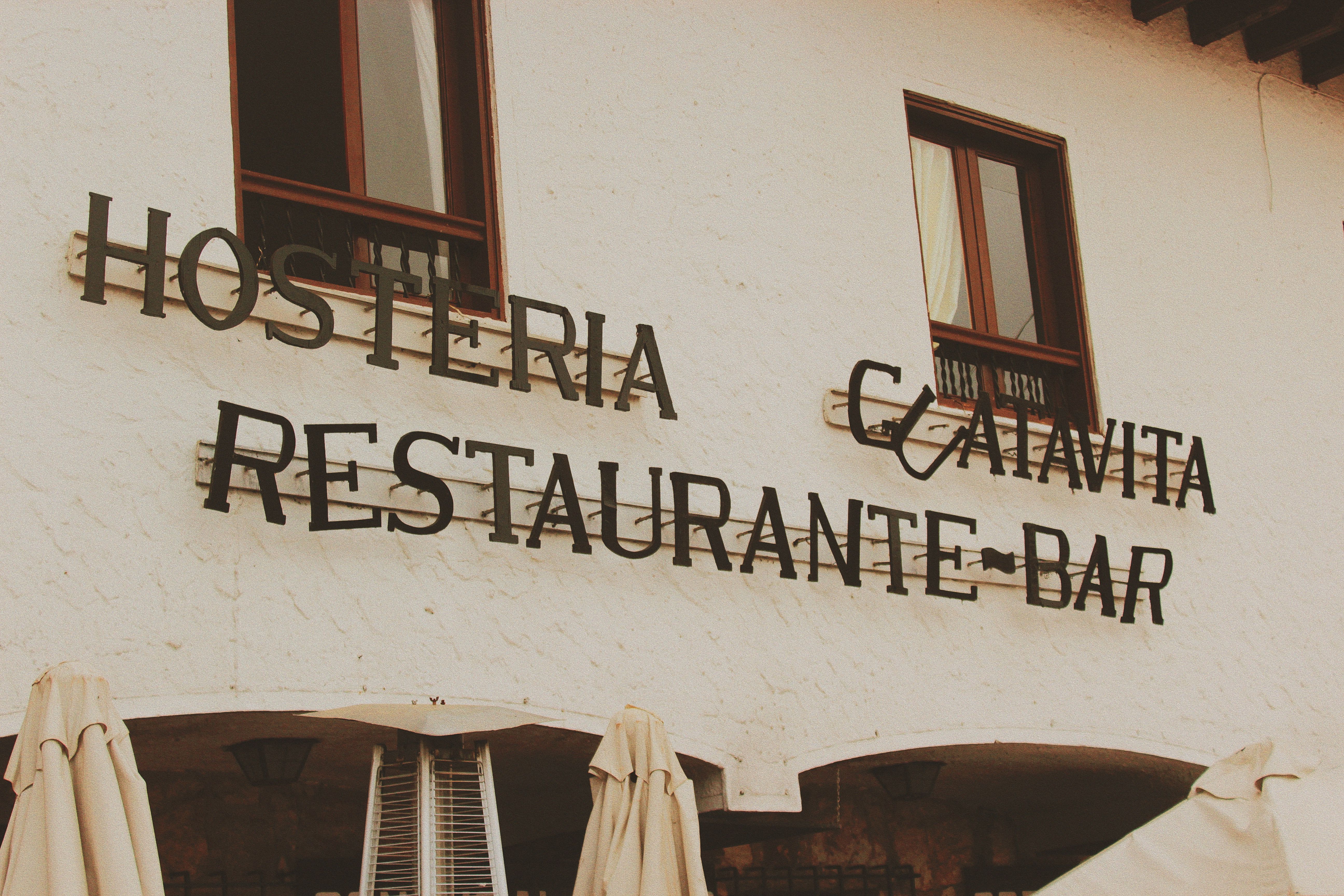 Exterior view of a restaurant bar facade with retro signage and warm tone aesthetics.