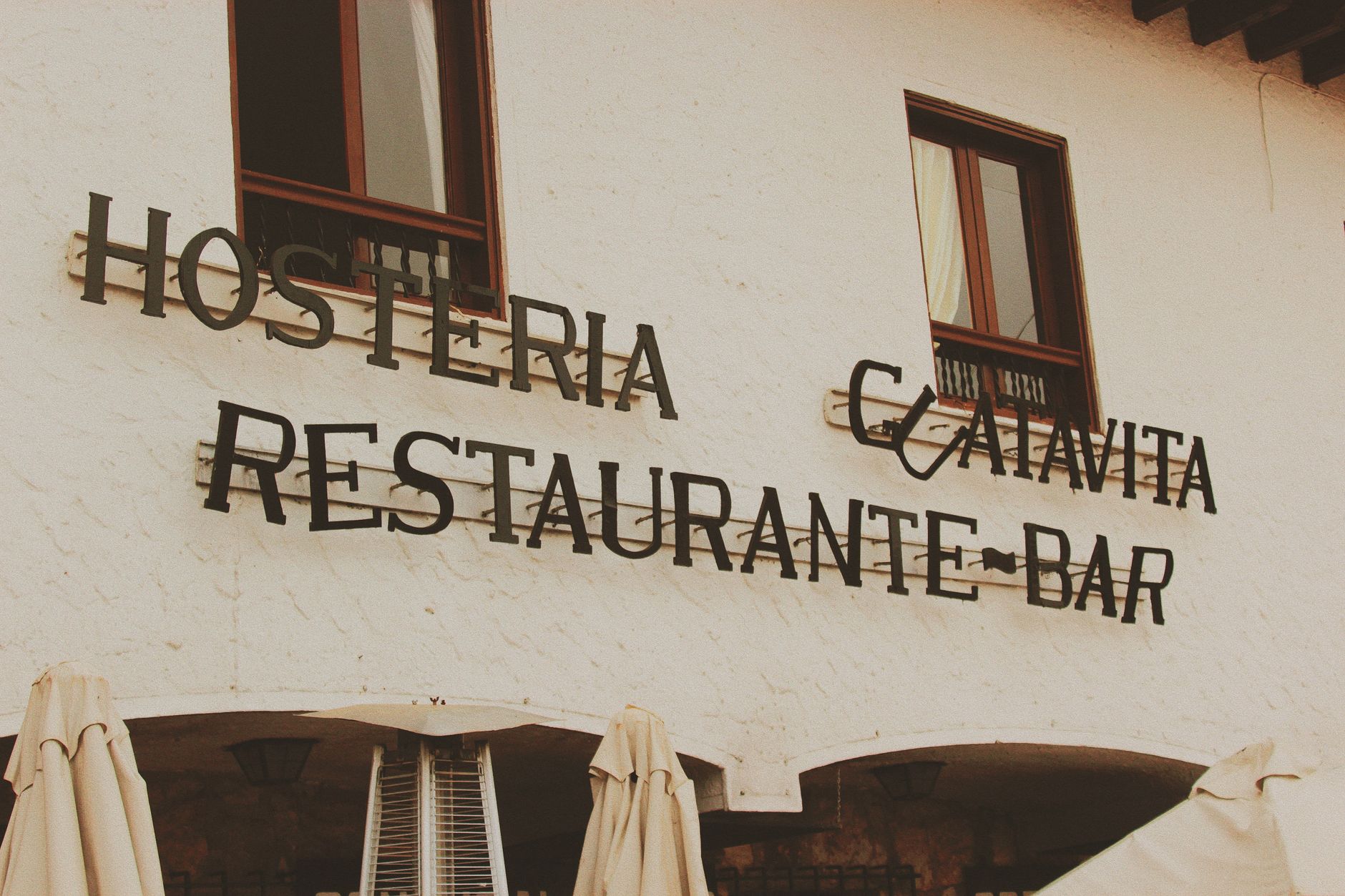 Exterior view of a restaurant bar facade with retro signage and warm tone aesthetics.