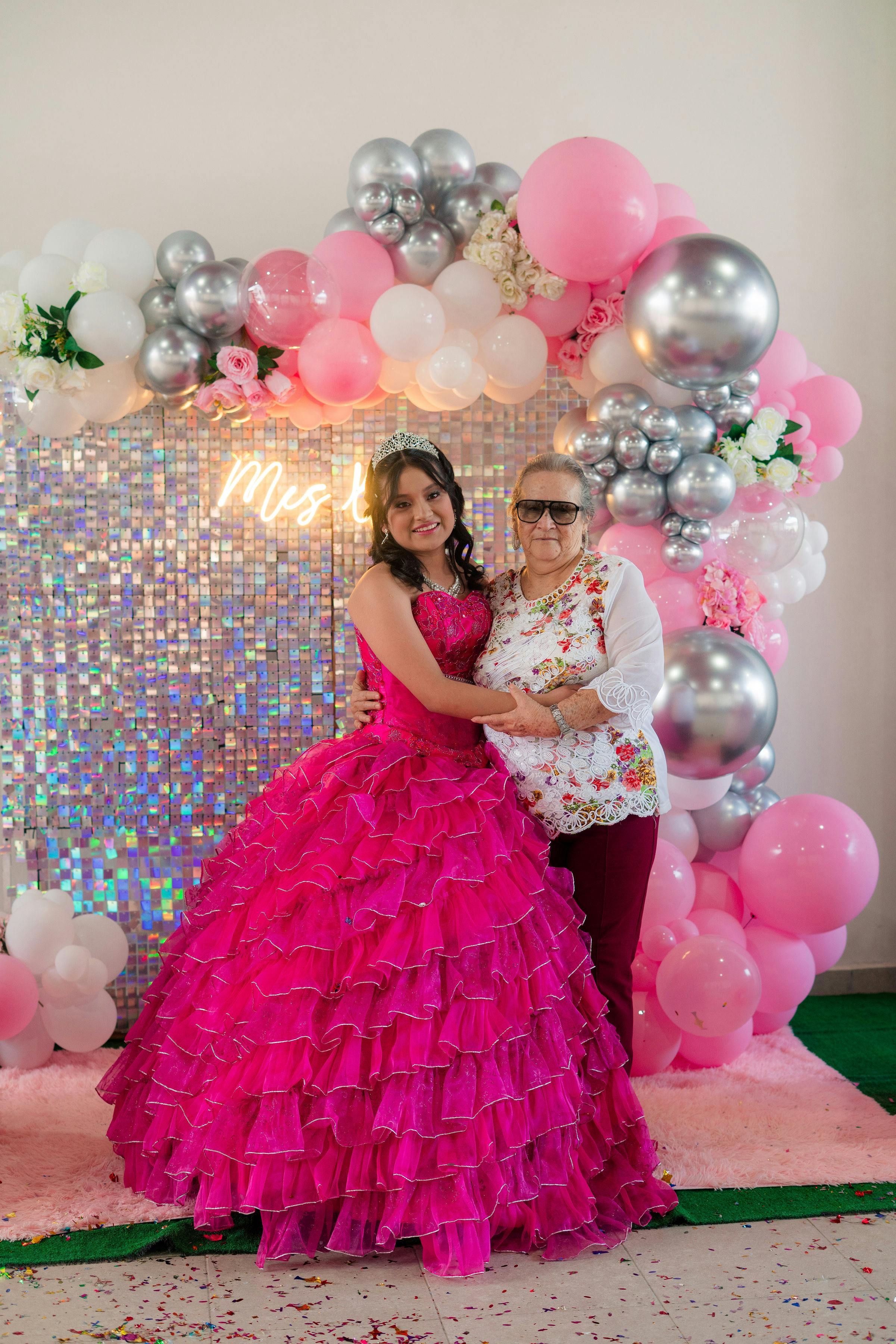 Gratis Una giovane ragazza in abito da ballo rosa e una donna anziana posano gioiosamente a una quinceañera. Foto a disposizione