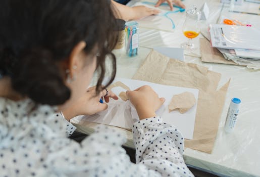 Adults in a Japanese art class engaging in a creative craft activity, focusing on paper cutouts.