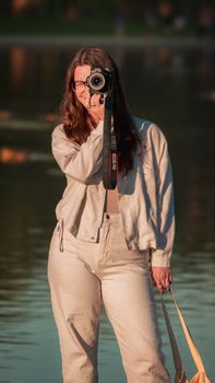 Female photographer with camera by the Reflecting Pool in Washington, DC during sunset.