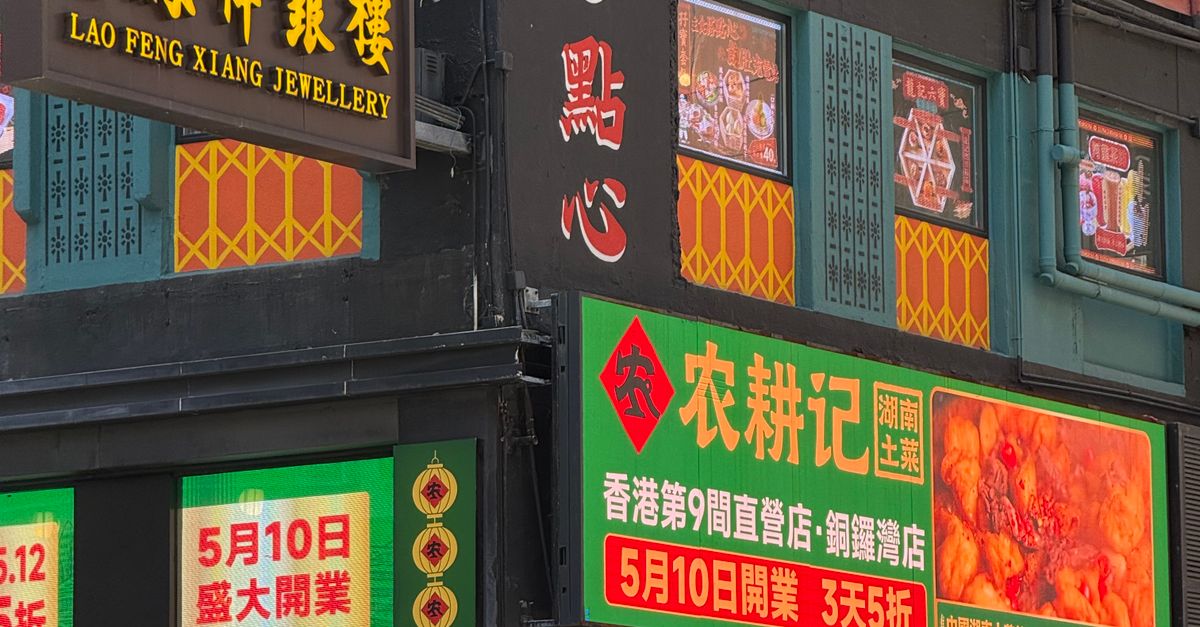 Lively street view with Asian storefronts and vibrant signs in urban setting.