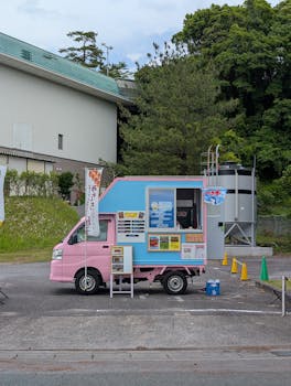 A colorful pink and blue food truck offering treats in Gamagori, Japan. Perfect for street food enthusiasts.