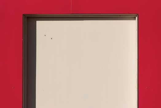 A minimalist architectural shot of a red and beige doorway with geometric composition.