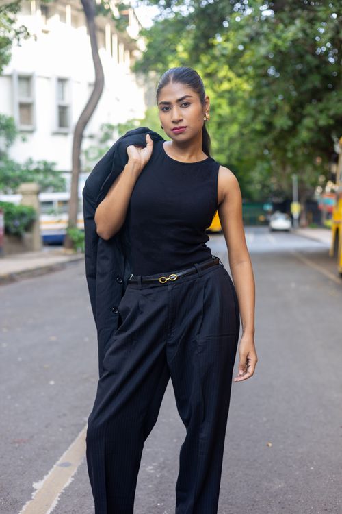 Free Confident woman in black attire posing outdoors on a city street, embracing urban fashion. Stock Photo