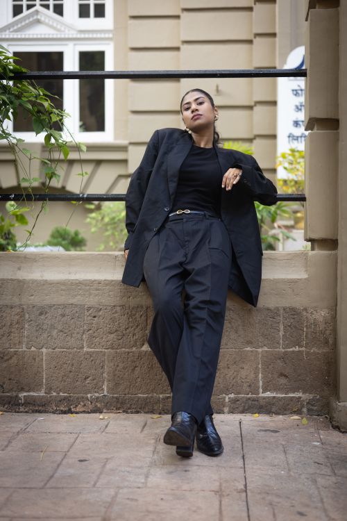 Free Portrait of a confident woman in stylish attire posing against an urban backdrop. Stock Photo