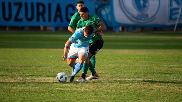Players in competitive soccer match fighting fiercely over possession of the ball on a sunny day.