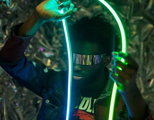 Free Person in reflective glasses and neon lights creates a futuristic look. Stock Photo