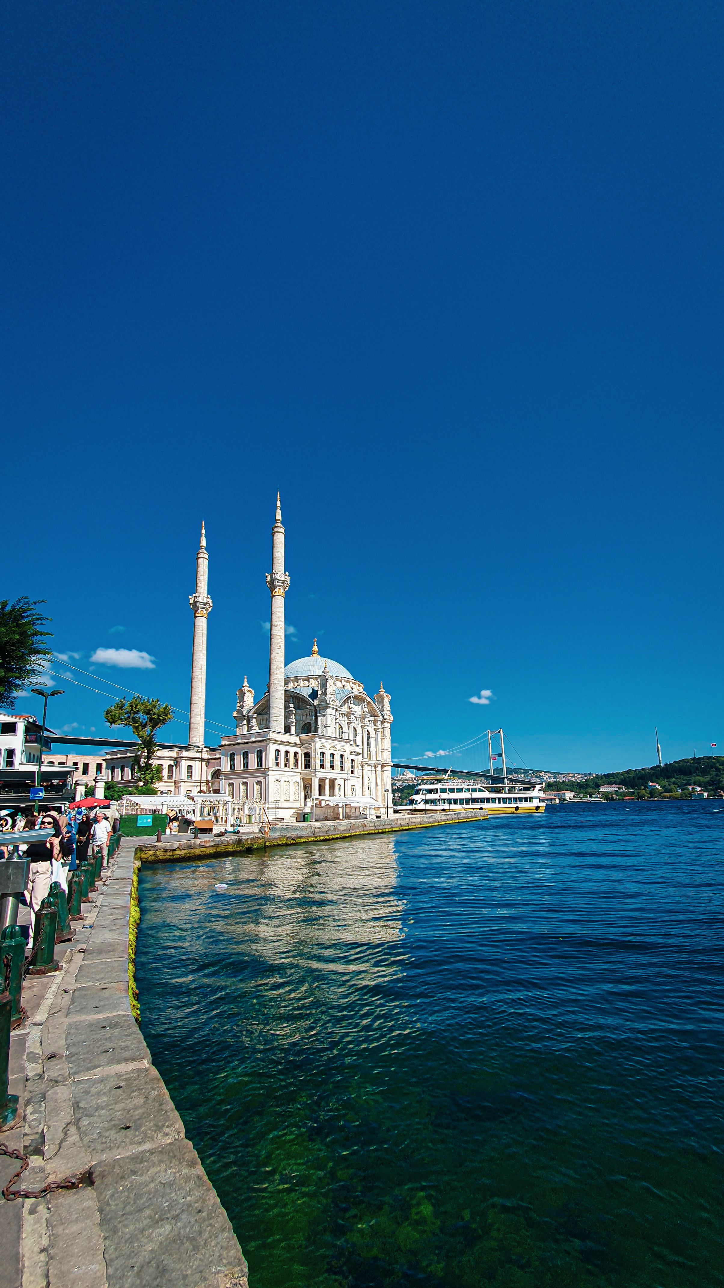 A beautiful view of Ortaköy Mosque by the Bosphorus Strait under a clear blue sky in Istanbul.
