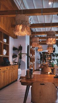Inviting wooden restaurant interior with warm lighting and tropical plants.