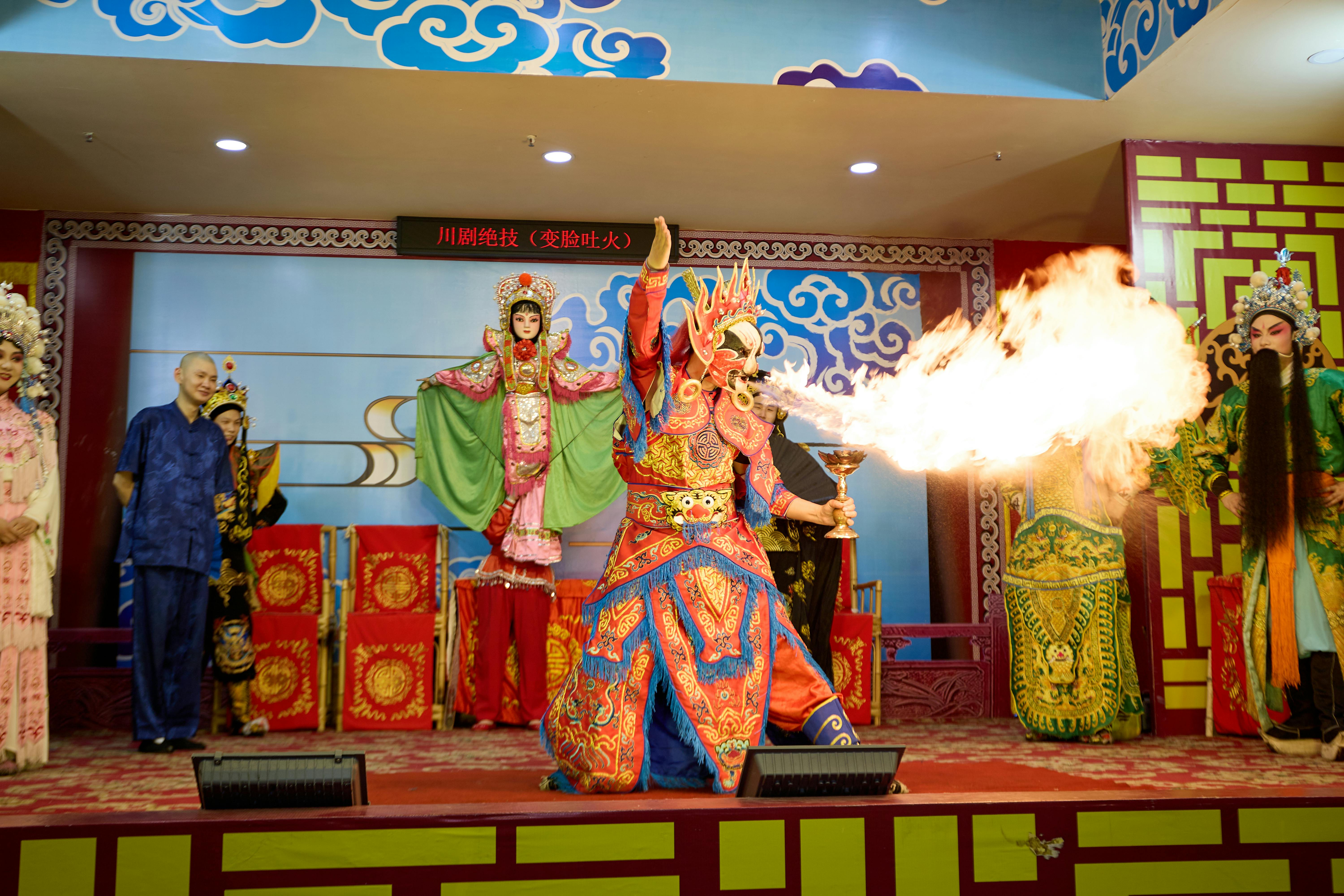 Gratis Pertunjukan panggung Opera Sichuan yang dramatis menampilkan kostum berwarna-warni dan aksi menyemburkan api. Foto Stok