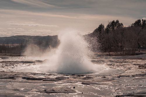 Free Dramatic eruption of a geyser set against Iceland's rugged, natural backdrop. Stock Photo