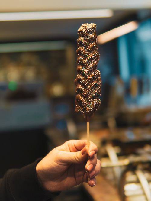 Free Delicious chocolate-covered treat with colorful sprinkles in Brugge, Belgium. Stock Photo