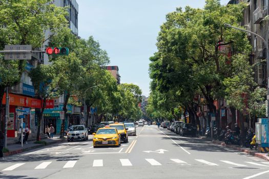 View of a busy urban street with taxis and shops, vibrant city scene.