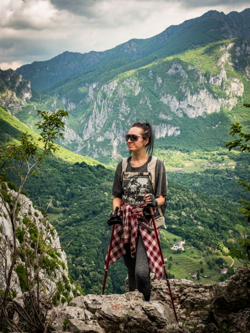 Free Woman hiking in Lombardy, Italy, enjoying breathtaking alpine mountain views with lush greenery. Stock Photo