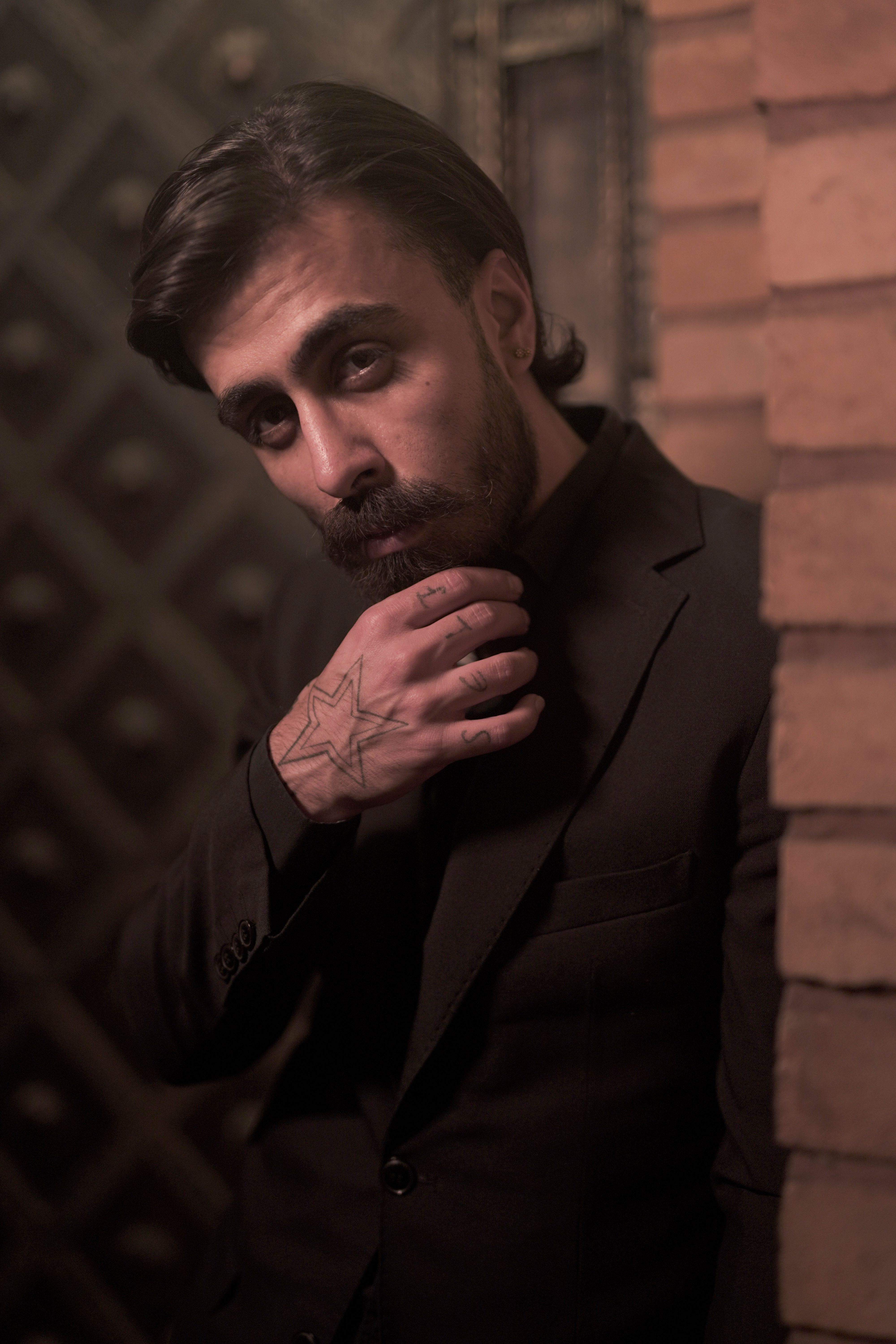 Moody Portrait of Bearded Man in Suit with Hand Tattoo