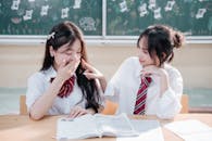 Two Students Sharing a Light Moment in Classroom