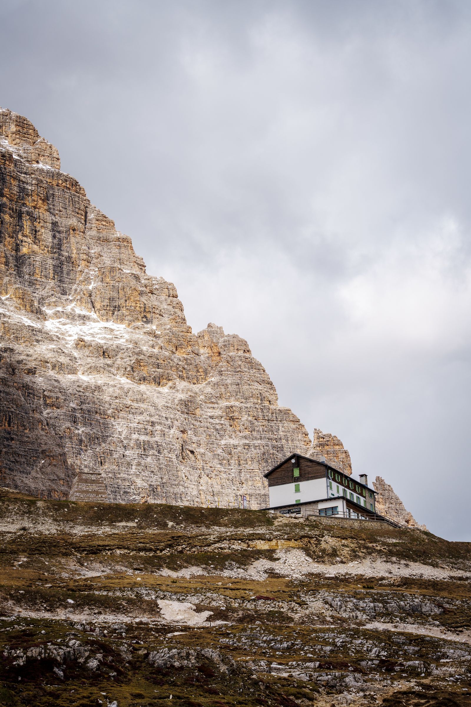 A remote mountain refuge below jagged Dolomite peaks in the Veneto, Italy