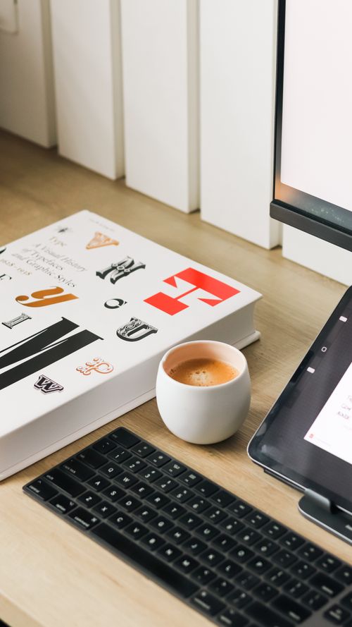 無料 タブレット、キーボード、本、コーヒーを備えた洗練されたデスクセットアップは、生産性に最適です。 写真素材