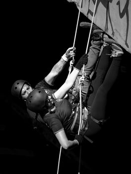 A thrilling black and white shot of two climbers scaling an indoor wall.