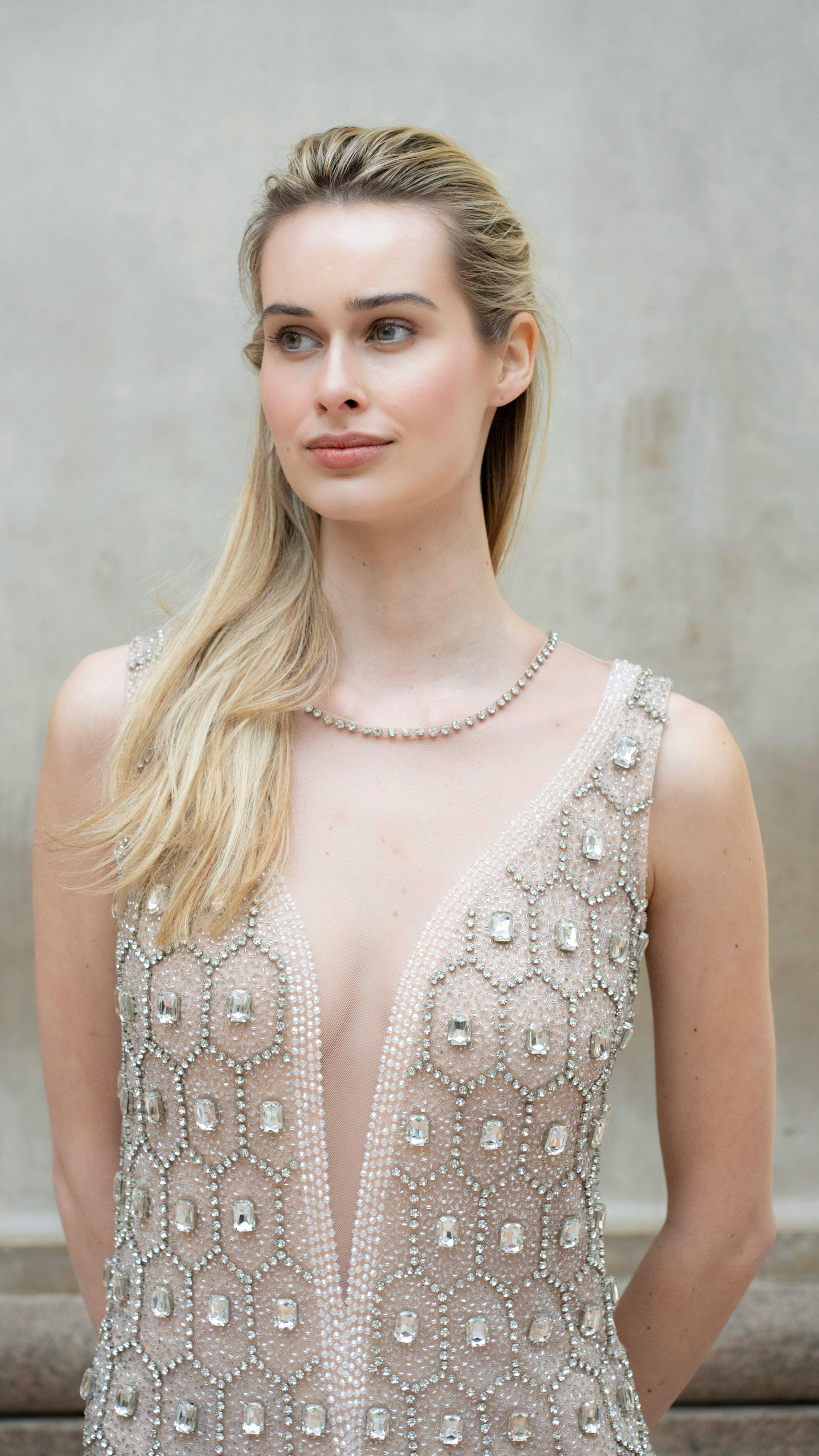 A graceful fashion model posing in Milan, showcasing a luxurious evening gown with intricate beadwork.