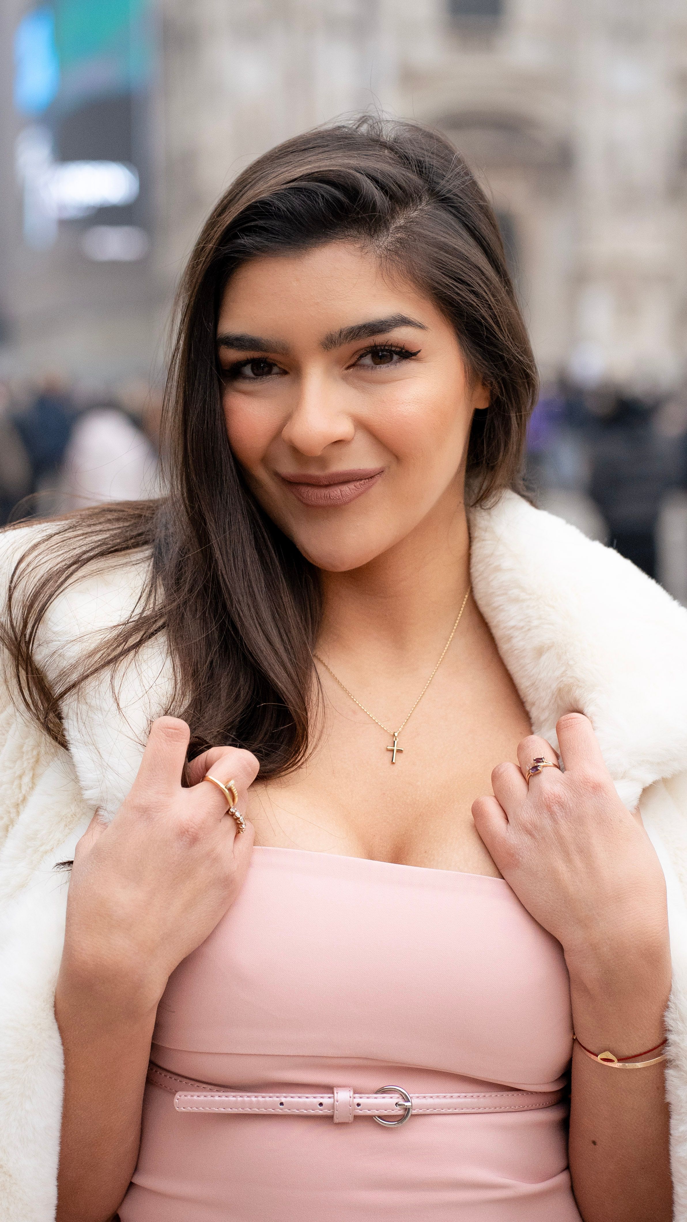 Stylish young woman posing confidently outdoors in Milan, Italy. Fashionable attire with a backdrop of the city's architecture.