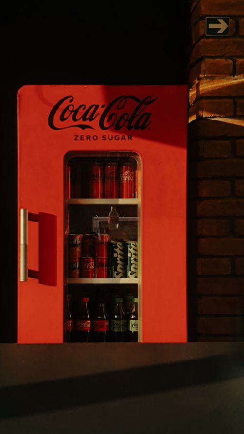 Free Coca-Cola Zero Sugar vending machine in a cafe setting with warm lighting. Stock Photo